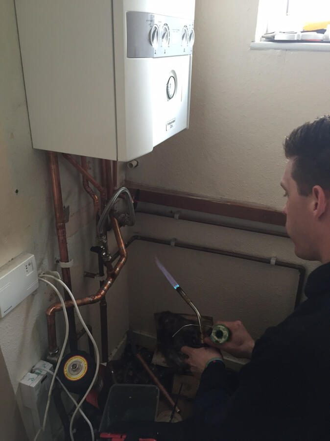 Gas Safe registered plumber working on boiler repair
